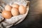 Chicken brown eggs in sackcloth on wooden backgroundChicken brown eggs in sackcloth on wooden background