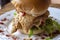 Chicken burger with salad on white plate, snack food closeup. Restaurant or eatery menu photo.