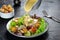 Chicken Caesar salad with the classic dressing being poured and croutons