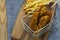 Chicken coujons coated in breadcrumbs in a wire metal basket, with fries