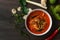 Chicken curry with different spices on dark background