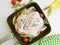 Chicken damp, whole in a frying pan food preparation on a white wooden background, tomatoes, lemon