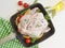 Chicken damp, whole in a frying pan preparation on a white wooden background, tomatoes, lemon