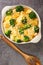 Chicken Divan is a creamy casserole that traditionally made with a chicken, broccoli, cream, cheese close up in the dish. vertical