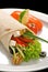 Chicken doner kebab and fresh vegetables in roll of pita bread lavash