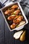 Chicken drumstick baked with honey pears and red onion close-up. Vertical top view