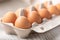 Chicken eggs in cardboard box on wooden table. Egg Yolk Cooking