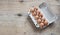 Chicken eggs in carton on wooden table. Eggs Yolk Cooking Top View