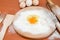 Chicken eggs, flour, whisk and rocking chair on the table. The process of making dough. Broken egg in flour.