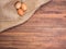 Chicken eggs on old rural wooden table boards and burlap vintage background, photo top view. Hessian texture with eggs