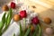 Chicken eggs, red tulips on a white crocheted tablecloth.