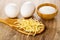 Chicken eggs, spoon with egg noodles, bowl with salt on wooden table