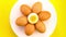 Chicken eggs whole and half on white turning on yellow background.