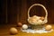 Chicken eggs in a wicker basket on a wooden table