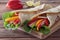 Chicken fajitas with grilled onions and bell peppers and tortillas on wooden board. Soft focus