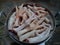 Chicken feet that have been cleaned and washed are placed in an aluminum pan. Raw chicken feet. Closeup photo.