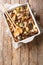 Chicken fricassee with porcini mushrooms, potatoes and rosemary close-up in a baking dish. Vertical top view