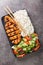 Chicken katsu is a traditional Japanese dish served with rice and vegetables salad closeup in the plate. Vertical top view