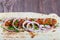 Chicken kebab from pita bread, onion and greens on dark wooden background. Shashlik or Shish kebab.