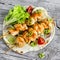 Chicken kebabs and fresh vegetable salad on a homemade tortilla