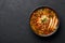 Chicken Manchow Soup in black bowl at dark slate background. Chicken Manchow Soup is indo-chinese cuisine dish