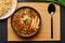 Chicken Manchow Soup in black bowl at dark slate background. Chicken Manchow Soup is indo-chinese cuisine dish