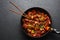 Chicken Manchurian in pan at black concrete background. Chicken Manchurian is Indian Chinese cuisine dish with Chicken breasts,
