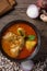 Chicken massaman curry in black bowl with herb and spices on wooden background. Thai authentic food called massaman kai.