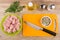 Chicken meat in green bowl, cutting board, spices and knife