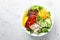 Chicken meat lunch bowl with fresh salad leaves, corn, cucumber, sweet pepper and quinoa