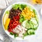 Chicken meat lunch bowl with fresh salad leaves, corn, cucumber, sweet pepper and quinoa