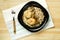 Chicken meatballs with mushrooms in a creamy sauce with green buckwheat in a plate on a linen napkin.