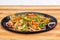 Chicken mushroom and capsicum stir fry recipe served on a sizzling plate.