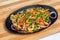 Chicken mushroom and capsicum stir fry recipe served on a sizzling plate.