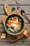 Chicken noodle soup on a cutting board with toast, wooden plank table. Top view, flat lay