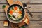 Chicken noodle soup on a cutting board with toast, wooden plank table. Top view, flat lay