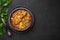 A Chicken Patiala in black bowl on dark slate table top. Murg Patiala is indian cuisine curry dish. Asian food and meal