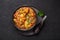 A Chicken Patiala in black bowl on dark slate table top. Murg Patiala is indian cuisine curry dish. Asian food and meal