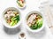 Chicken, rice noodles, boiled chicken, cabbage bok choi, spices soup on white background, top view.