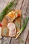 Chicken roll in grid decorated lettuce leaf isolated on wooden background. Fresh meat product whole and partly sliced