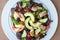 Chicken salad with avocado, mixed greens, cucumbers, tomatoes, and olives.