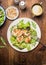 Chicken salad with green salad leaves, pine nuts and olive oil dressing. Healthy diet salad on rustic wooden background, top