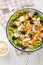 Chicken salad with mushrooms, carrots, celery, olives, cheese and lettuce close-up in a bowl. Vertical top view