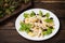 Chicken salad, pears, dried gooseberries and currants, cheese on basil leaves. Wooden background. Top view. Close-up