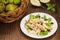 Chicken salad, pears, dried gooseberries and currants, cheese on basil leaves. Wooden background. Top view. Close-up