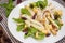 Chicken salad, pears, dried gooseberries and currants, cheese on basil leaves. Wooden background. Top view. Close-up