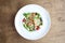 Chicken salads in white plate on the wooden background