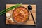 Chicken and Sausage Gumbo soup in black bowl on dark slate backdrop. Gumbo is louisiana cajun cuisine soup with roux. American USA