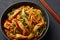 Chicken Schezwan Noodles or Hakka or Chow Mein in black bowl at dark background. Schezwan Noodles is indo-chinese cuisine hot dish