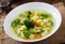 Chicken soup with broccoli, green peas, carrots and celery